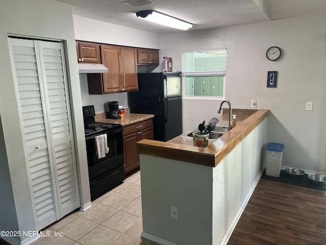 117 Eliam Rd, Melrose, FL 32666 - kitchen featuring black appliances, a sink, a peninsula, under cabinet range hood, and baseboards