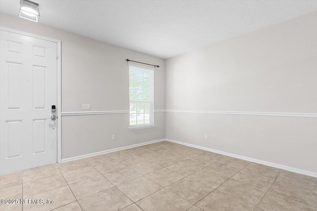1011 Wetland Ridge Cir, Middleburg, FL 32068 - unfurnished room featuring a textured ceiling, light tile patterned floors, and baseboards