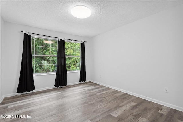 318 W Lafayette St, Starke, FL 32091 - unfurnished room with a textured ceiling, wood finished floors, and baseboards