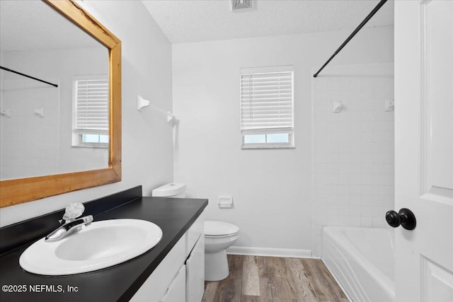 318 W Lafayette St, Starke, FL 32091 - bathroom with vanity, wood finished floors, a textured ceiling, toilet, and shower / tub combination