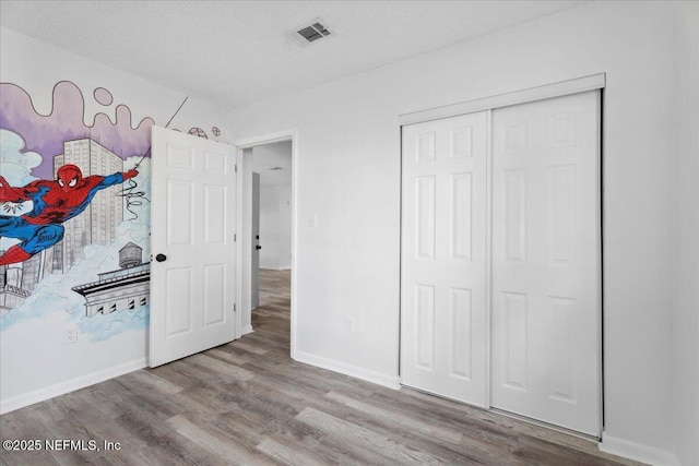 318 W Lafayette St, Starke, FL 32091 - unfurnished bedroom featuring wood finished floors, baseboards, a closet, and a textured ceiling