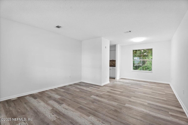 318 W Lafayette St, Starke, FL 32091 - spare room featuring light wood-style floors, a textured ceiling, and baseboards