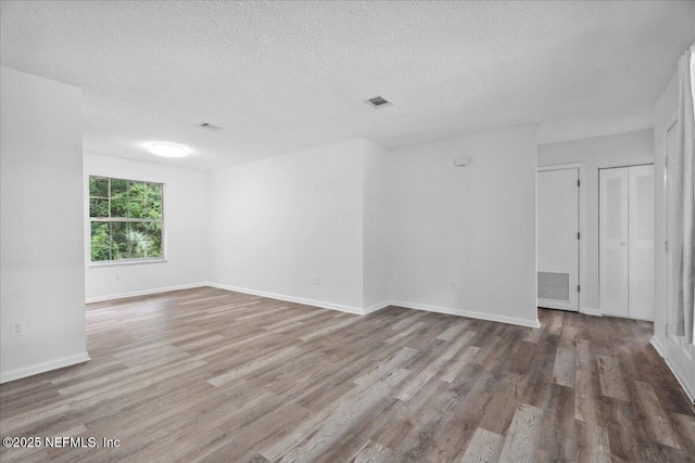 318 W Lafayette St, Starke, FL 32091 - empty room featuring wood finished floors, a textured ceiling, and baseboards