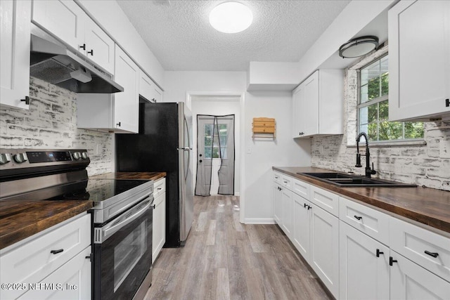 318 W Lafayette St, Starke, FL 32091 - kitchen with electric stove, butcher block countertops, under cabinet range hood, a textured ceiling, and wood finished floors
