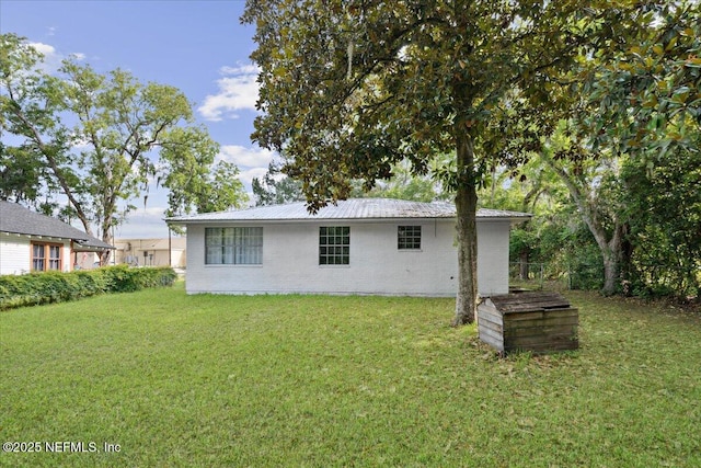 318 W Lafayette St, Starke, FL 32091 - back of house with a yard, metal roof, and brick siding