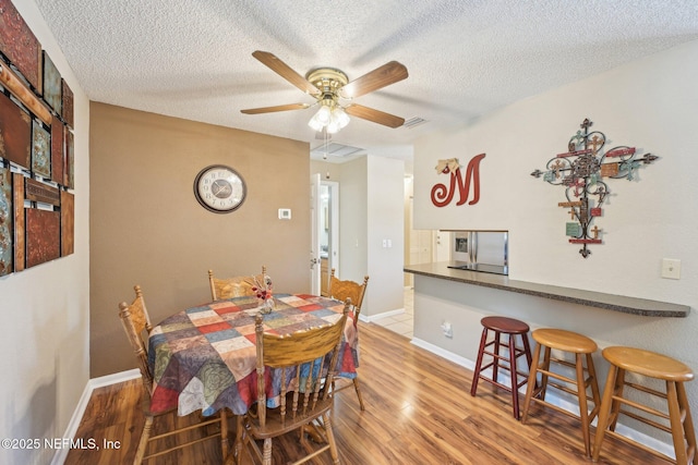 1515 Husson Ave, Palatka, FL 32177 - dining space with a textured ceiling, wood finished floors, a ceiling fan, and baseboards