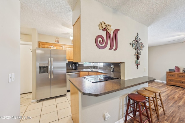 1515 Husson Ave, Palatka, FL 32177 - kitchen featuring appliances with stainless steel finishes, a textured ceiling, a sink, dark countertops, and a peninsula