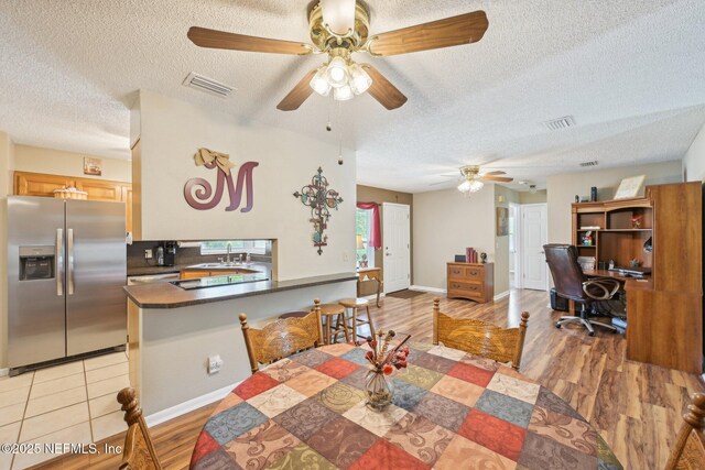 1515 Husson Ave, Palatka, FL 32177 - dining area with a textured ceiling, a ceiling fan, an office area, baseboards, and light wood-style floors