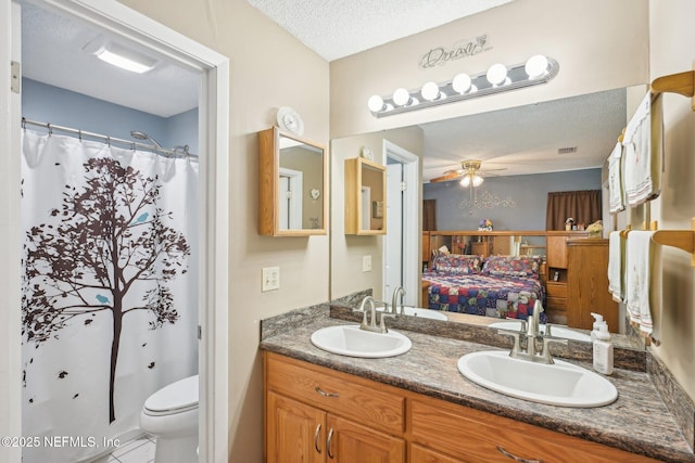 1515 Husson Ave, Palatka, FL 32177 - ensuite bathroom with ceiling fan, a textured ceiling, double vanity, toilet, and tile patterned floors