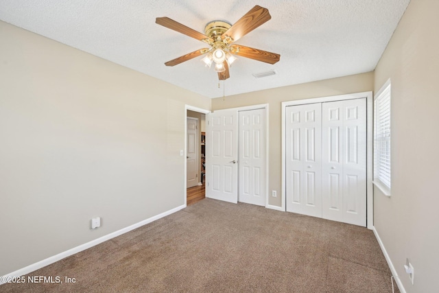 1515 Husson Ave, Palatka, FL 32177 - unfurnished bedroom with two closets, carpet, baseboards, a textured ceiling, and ceiling fan