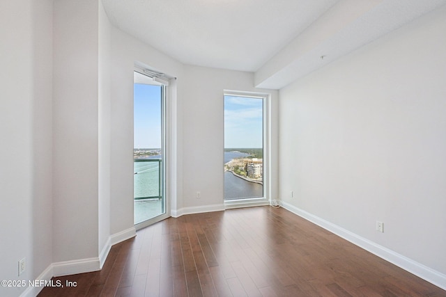 1431 Riverplace Blvd Unit 1707, Jacksonville, FL 32207 - spare room featuring dark wood-type flooring, baseboards, and a water view