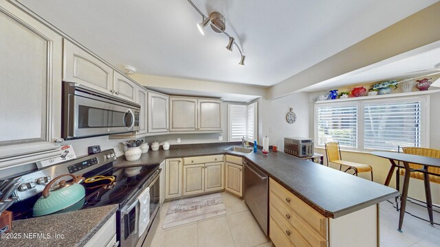 21 Mid Pines Cir, Palm Coast, FL 32137 - kitchen featuring stainless steel appliances, a sink, dark countertops, and a peninsula