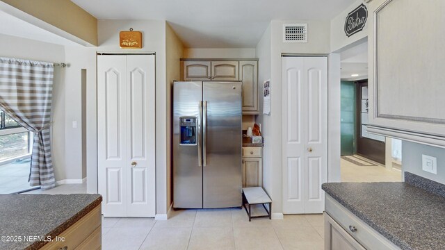 21 Mid Pines Cir, Palm Coast, FL 32137 - kitchen featuring stainless steel fridge with ice dispenser, dark countertops, light tile patterned flooring, and baseboards