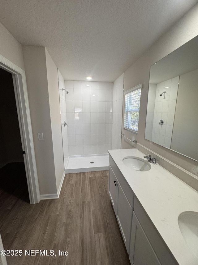 47 Laguna Forest Trl, Palm Coast, FL 32164 - full bathroom with wood finished floors, tiled shower, double vanity, and a textured ceiling