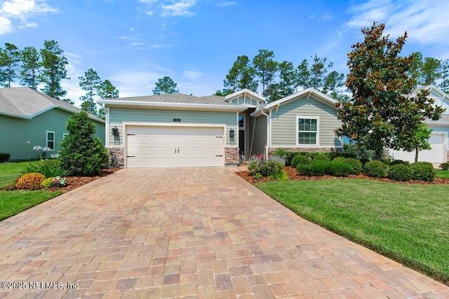 488 Montserrat Dr, Saint Augustine, FL 32092 - view of front facade with stone siding, decorative driveway, a front yard, and a garage