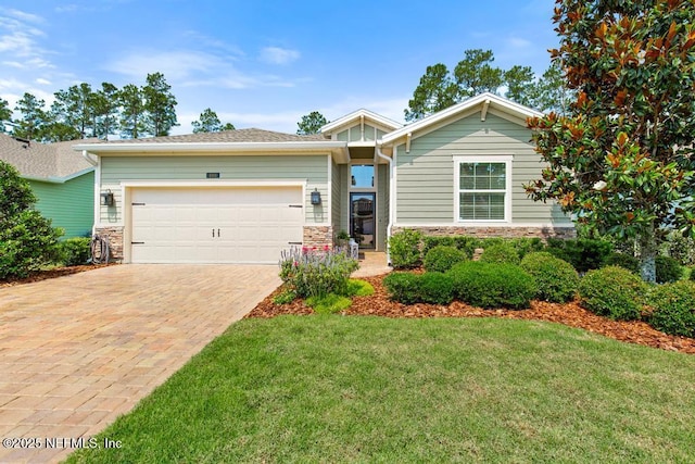 488 Montserrat Dr, Saint Augustine, FL 32092 - view of front of home featuring stone siding, driveway, a front yard, and an attached garage
