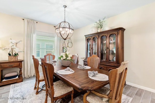 488 Montserrat Dr, Saint Augustine, FL 32092 - dining space with a chandelier, baseboards, and wood tiled floors
