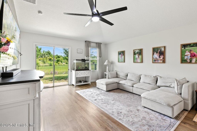 12097 Grand Herring Way, Jacksonville, FL 32219 - living area featuring a ceiling fan, light wood-style flooring, and a textured ceiling