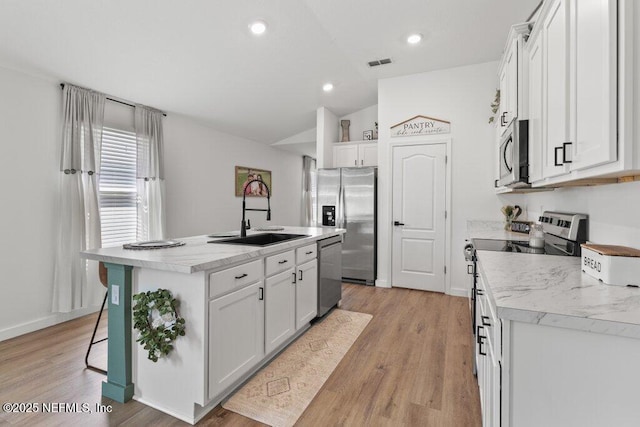 12097 Grand Herring Way, Jacksonville, FL 32219 - kitchen featuring stainless steel appliances, a sink, lofted ceiling, a center island with sink, and white cabinets
