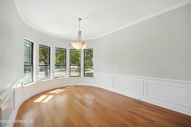 10065 Ecton Ln, Jacksonville, FL 32246 - spare room featuring plenty of natural light, crown molding, wood finished floors, a wainscoted wall, and a decorative wall