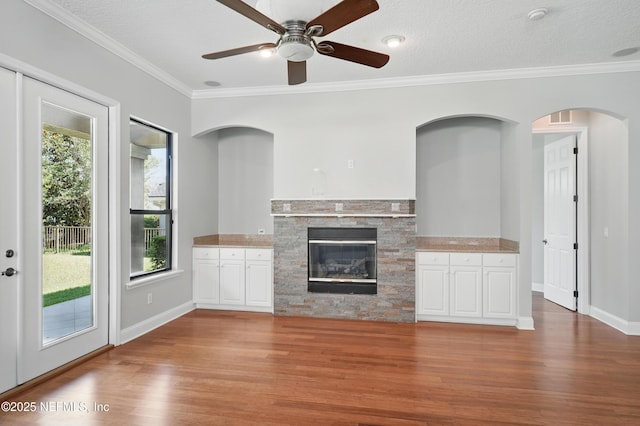 10065 Ecton Ln, Jacksonville, FL 32246 - unfurnished living room with wood finished floors, ceiling fan, a fireplace, crown molding, and baseboards