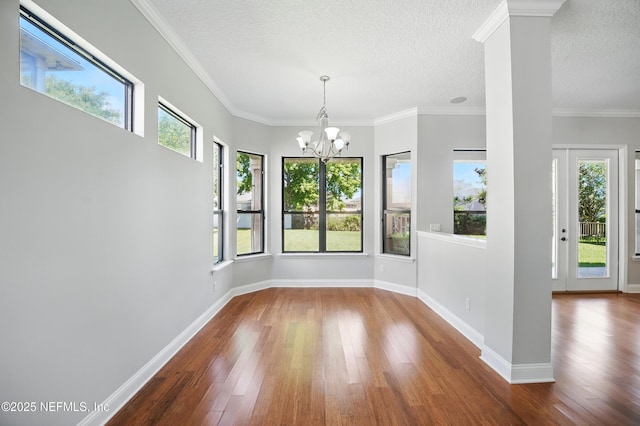 10065 Ecton Ln, Jacksonville, FL 32246 - unfurnished dining area with wood-type flooring, a chandelier, baseboards, a textured ceiling, and ornamental molding