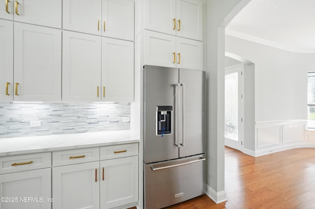 10065 Ecton Ln, Jacksonville, FL 32246 - kitchen featuring high end refrigerator, arched walkways, crown molding, backsplash, and light wood finished floors