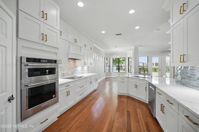 10065 Ecton Ln, Jacksonville, FL 32246 - kitchen featuring appliances with stainless steel finishes, a sink, custom exhaust hood, white cabinets, and recessed lighting