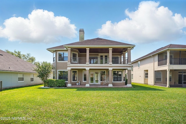 10065 Ecton Ln, Jacksonville, FL 32246 - back of house with a balcony, a chimney, a yard, and french doors