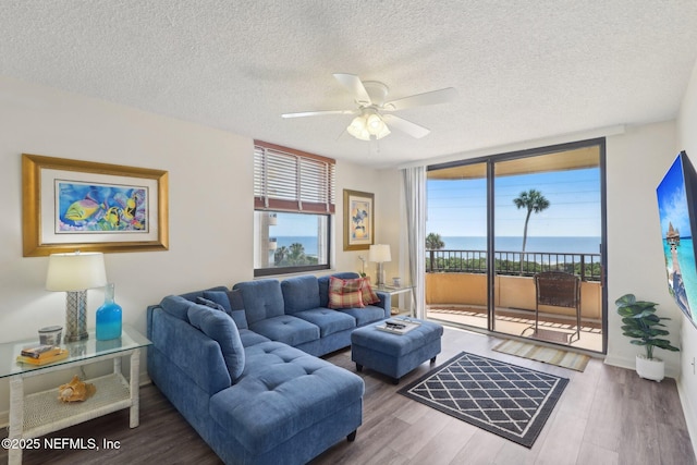 3360 Ocean Shore Blvd Unit 3070, Ormond Beach, FL 32176 - living area with ceiling fan, a textured ceiling, wood finished floors, a wall of windows, and baseboards