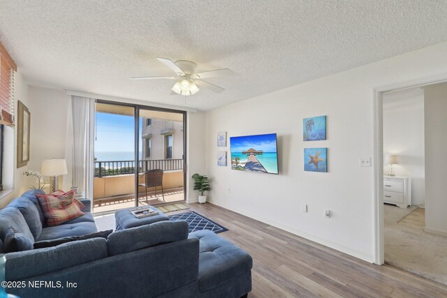 3360 Ocean Shore Blvd Unit 3070, Ormond Beach, FL 32176 - living area featuring wood finished floors, a ceiling fan, a textured ceiling, and baseboards