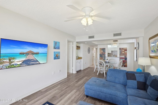3360 Ocean Shore Blvd Unit 3070, Ormond Beach, FL 32176 - living area with light wood finished floors, a chandelier, a textured ceiling, ceiling fan, and baseboards