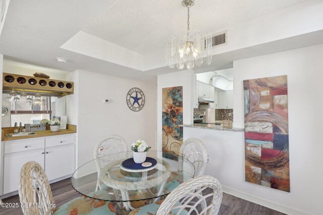 3360 Ocean Shore Blvd Unit 3070, Ormond Beach, FL 32176 - dining area with dark wood-type flooring, a chandelier, and a textured ceiling