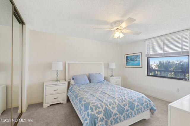 3360 Ocean Shore Blvd Unit 3070, Ormond Beach, FL 32176 - carpeted bedroom with a textured ceiling, a closet, baseboards, and a ceiling fan