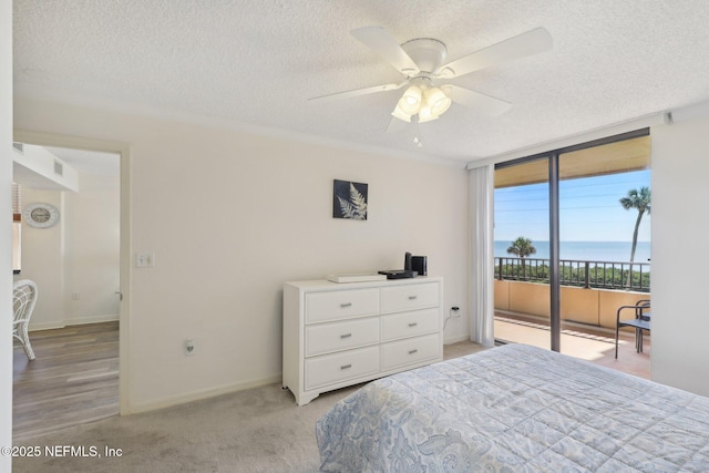 3360 Ocean Shore Blvd Unit 3070, Ormond Beach, FL 32176 - bedroom with access to exterior, a textured ceiling, floor to ceiling windows, a water view, and a ceiling fan