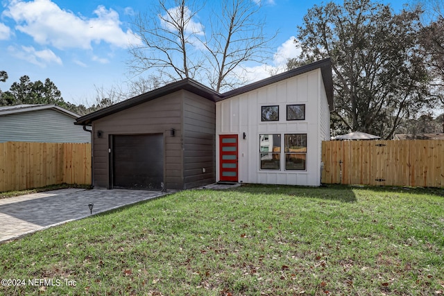 view of front facade with board and batten siding, decorative driveway, and an attached garage