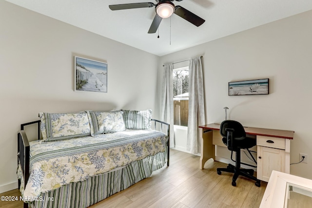 bedroom featuring wood finished floors, an office area, baseboards, and ceiling fan
