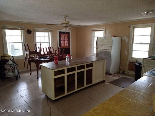 456 Malcross Ave, Jacksonville, FL 32208 - kitchen with freestanding refrigerator, tile countertops, a ceiling fan, healthy amount of natural light, and a textured ceiling
