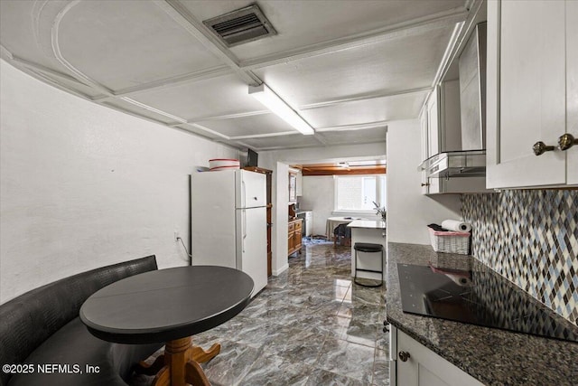 8615 2nd Ave, Jacksonville, FL 32208 - kitchen with freestanding refrigerator, dark marble finish floors, black electric cooktop, and white cabinets