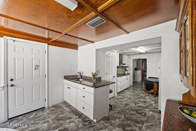 8615 2nd Ave, Jacksonville, FL 32208 - kitchen featuring white cabinets, a peninsula, a sink, and dark marble finish floors