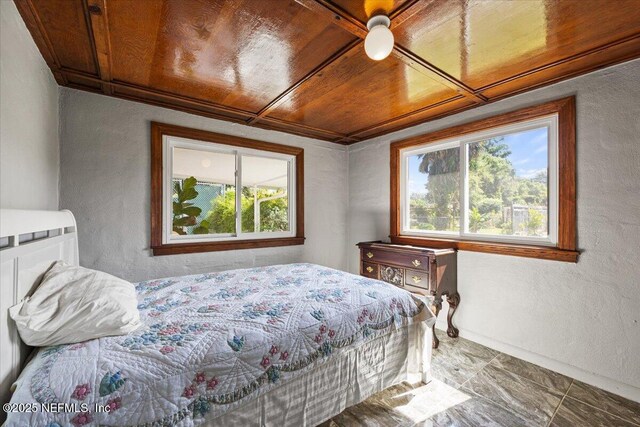 8615 2nd Ave, Jacksonville, FL 32208 - bedroom with a textured wall, multiple windows, wood ceiling, marble look tile flooring, and baseboards