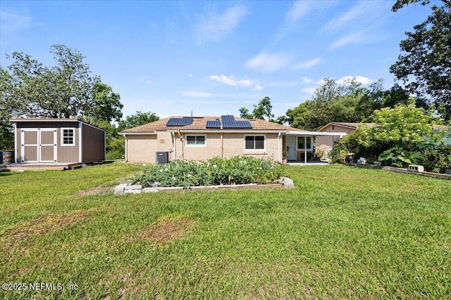 8615 2nd Ave, Jacksonville, FL 32208 - rear view of property with roof mounted solar panels, brick siding, and a lawn