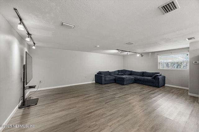 8615 2nd Ave, Jacksonville, FL 32208 - unfurnished living room with rail lighting, wood finished floors, a textured ceiling, and baseboards
