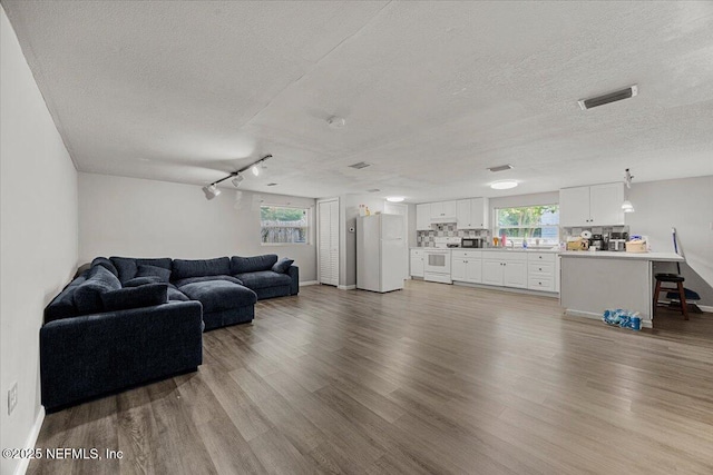 8615 2nd Ave, Jacksonville, FL 32208 - living area featuring a textured ceiling, wood finished floors, and baseboards