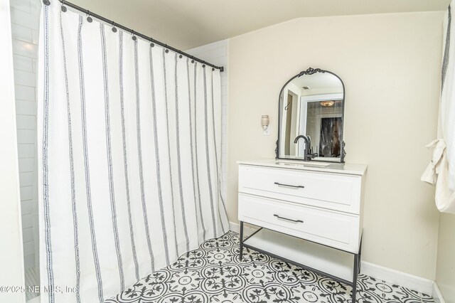 148 N 4th St, Macclenny, FL 32063 - bathroom with baseboards, vanity, and lofted ceiling