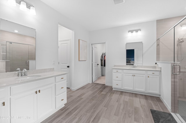 7242 Calamint Ave, Jacksonville, FL 32219 - bathroom with a shower stall, two vanities, and wood finished floors