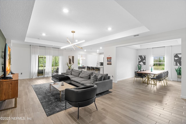 7242 Calamint Ave, Jacksonville, FL 32219 - living area with a raised ceiling, baseboards, light wood-type flooring, recessed lighting, and a chandelier