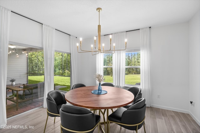 7242 Calamint Ave, Jacksonville, FL 32219 - dining room featuring a chandelier, healthy amount of natural light, light wood-style floors, and baseboards