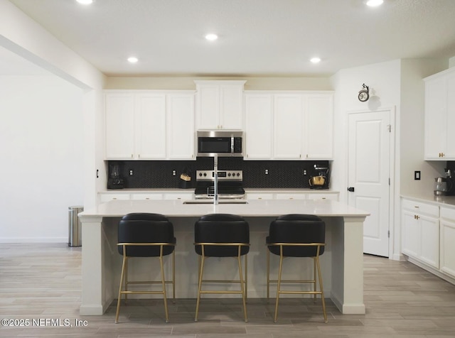 7242 Calamint Ave, Jacksonville, FL 32219 - kitchen with stainless steel appliances, a center island with sink, tasteful backsplash, a kitchen breakfast bar, and recessed lighting