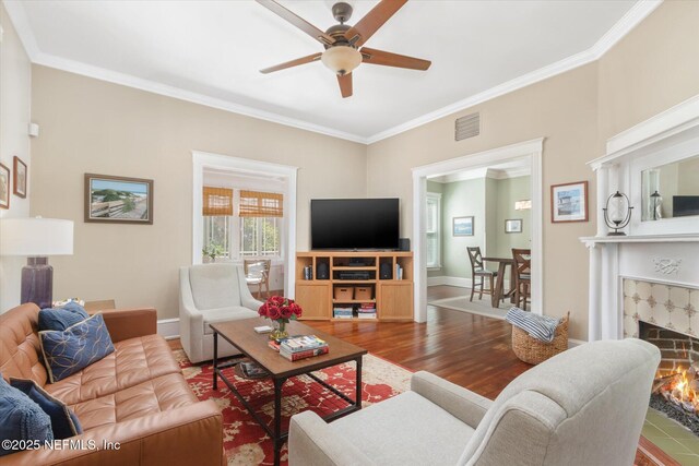 24 Sevilla St, Saint Augustine, FL 32084 - living area with wood finished floors, ornamental molding, a ceiling fan, a fireplace, and baseboards